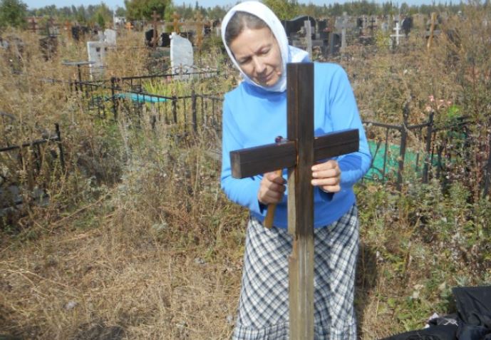 Олена прибралася біля моrил і сіла на лавку. Несподівано хтось торкнувся її плеча..